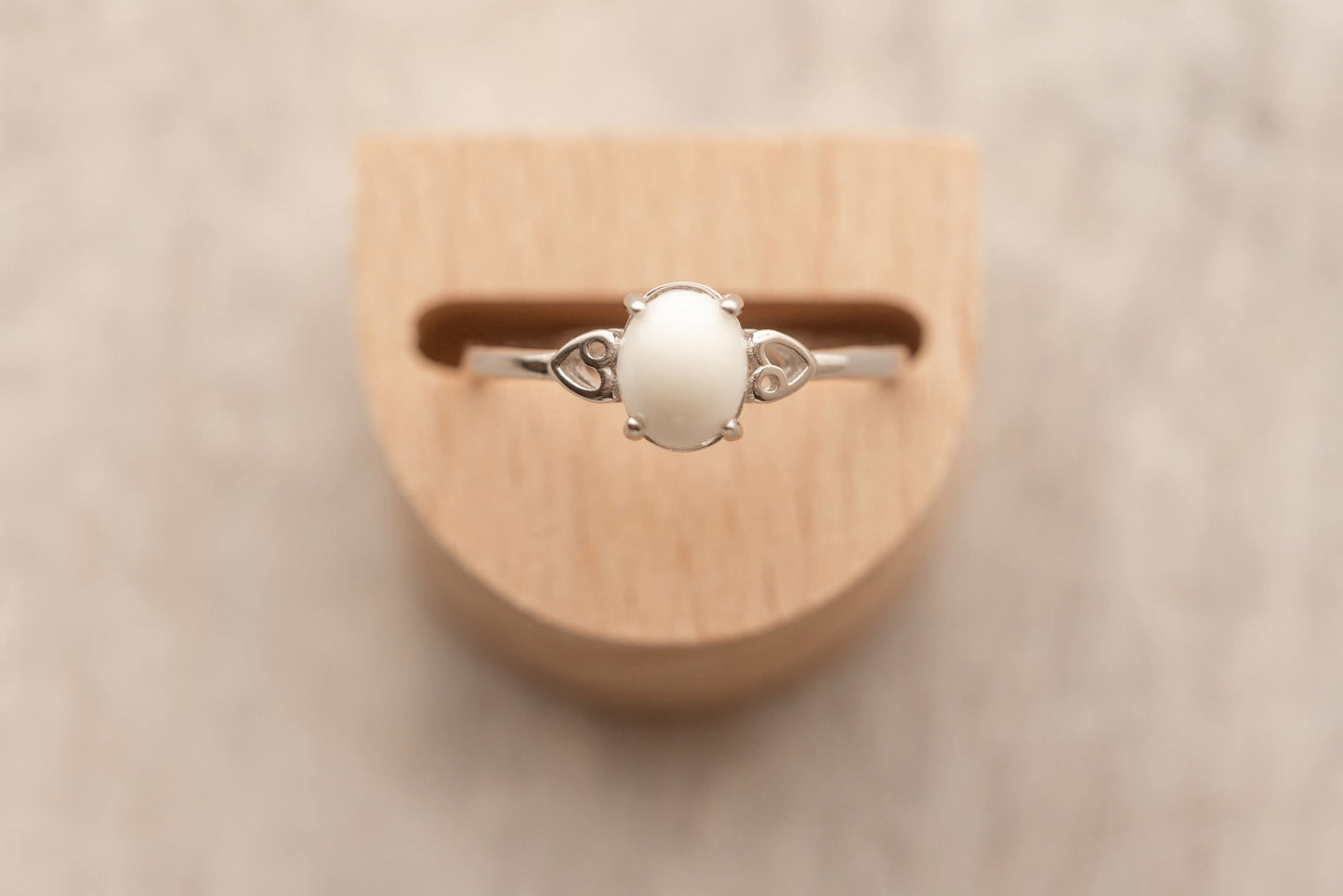 Bague en argent avec au centre un cabochon ovale de lait maternel entourée de 2 coeurs dans le corps de la bague