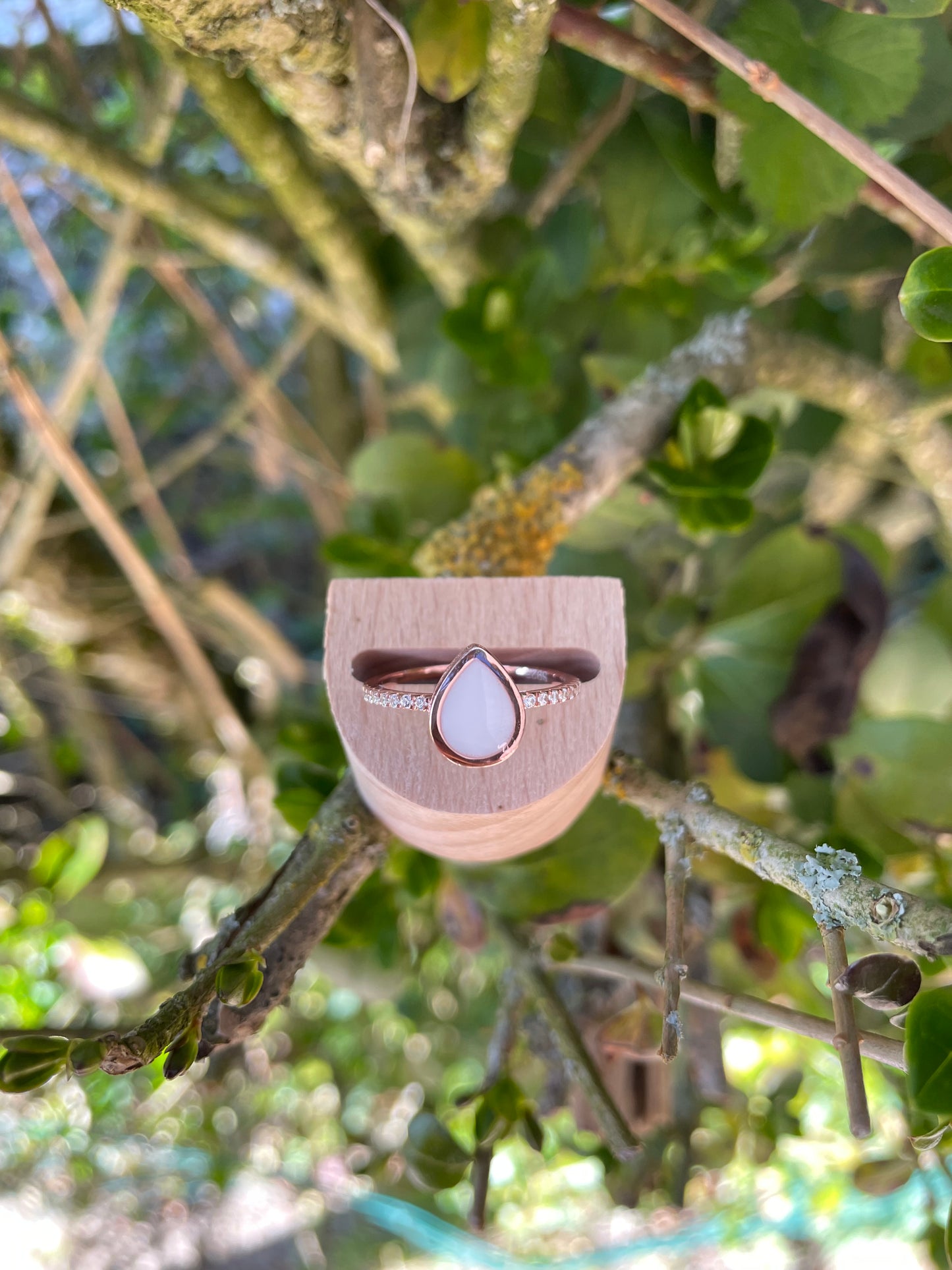 Bague en argent rose ornée de strass en forme de goutte remplie de lait maternel.