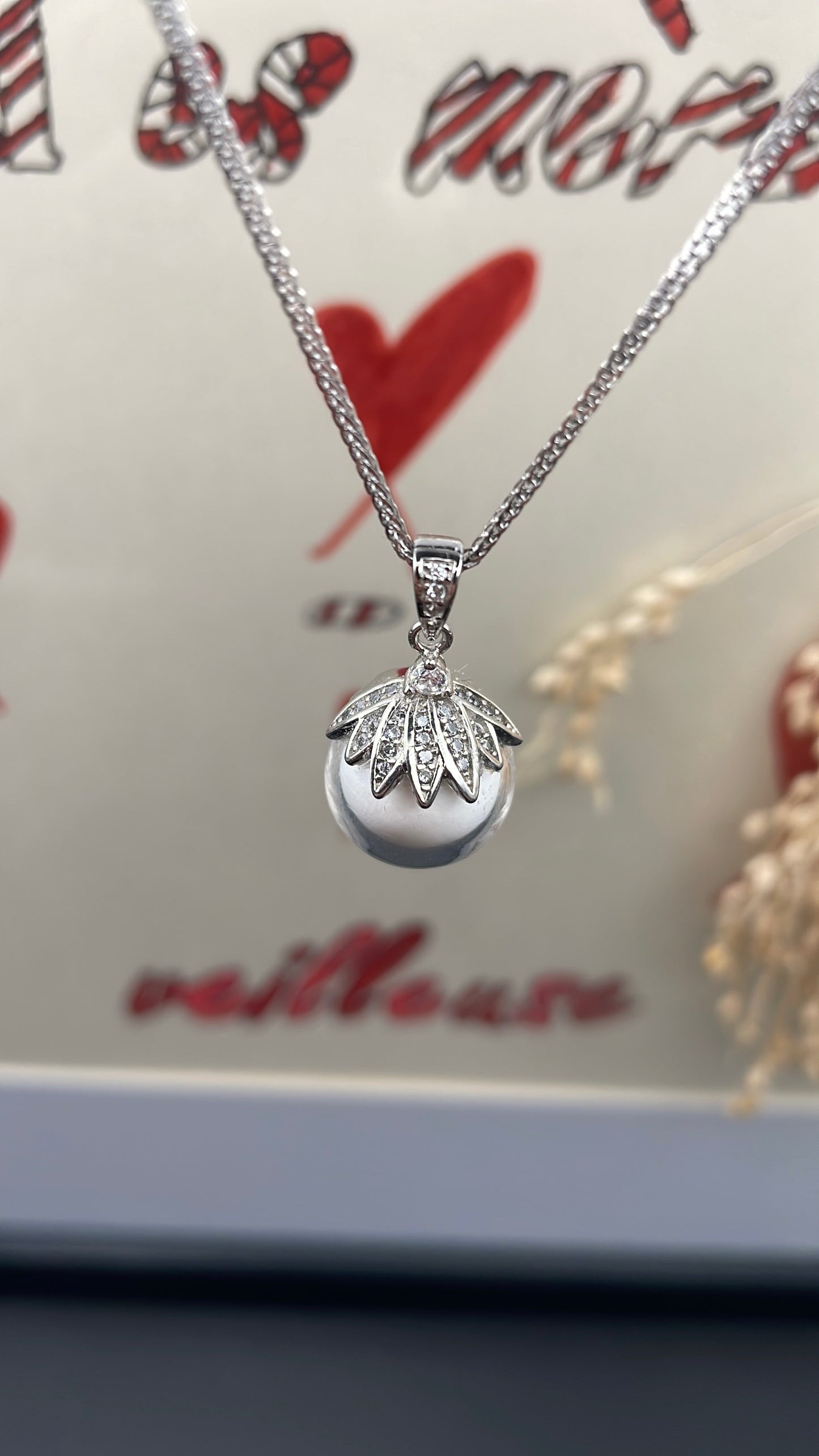 Pendentif orné d'une perle en verre contenant de la poule de lait maternel éternelle