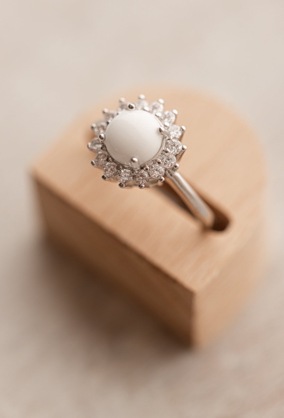 Bague souvenir avec un superbe cabochon de lait maternel et mèche de cheveux de bébé, entourée de strass étincellantes. 