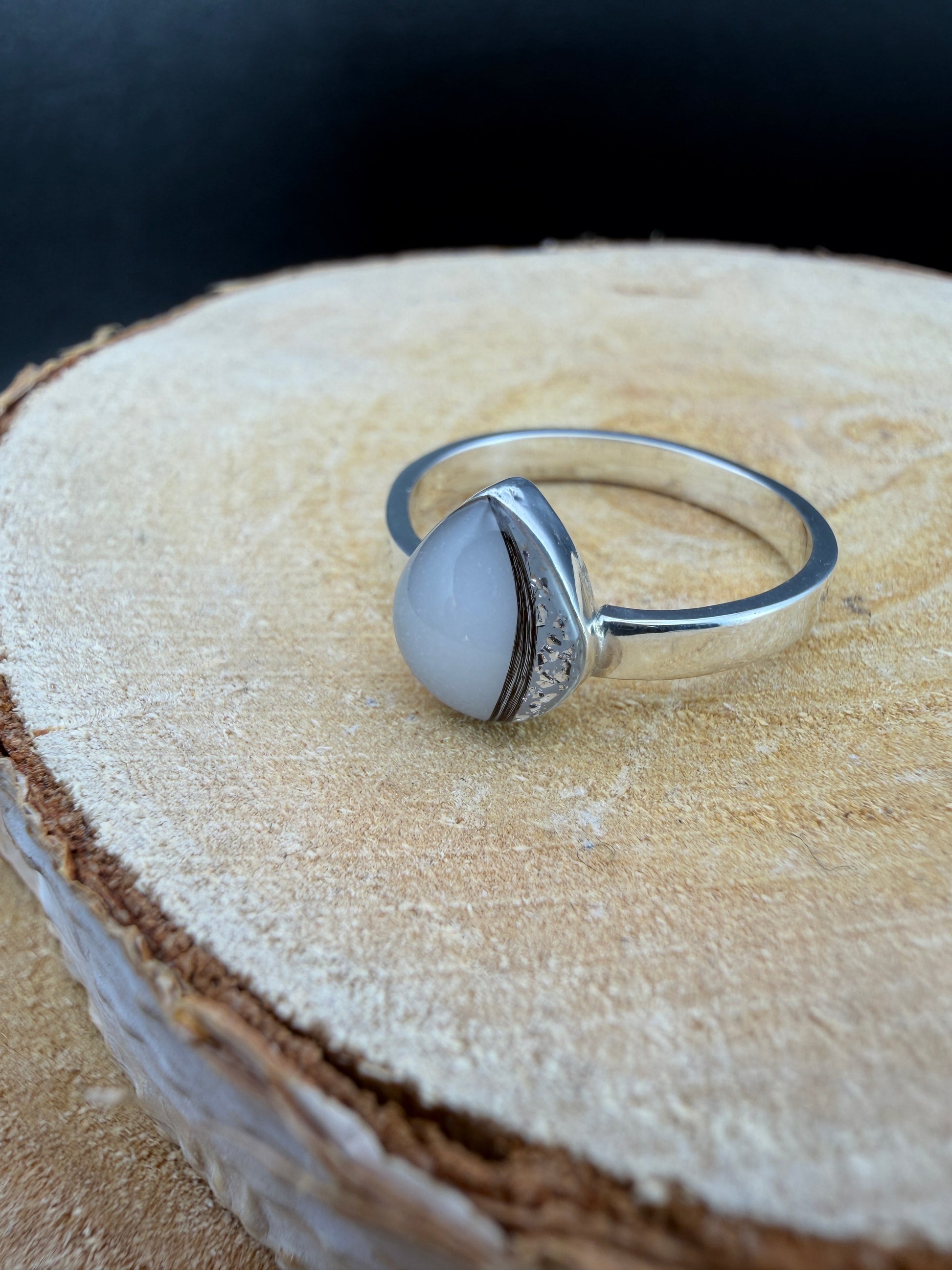 bague en forme de goutte avec mèche de cheveux de bébé, lait maternel et gravure des initiales sur l'extérieur de l'anneau