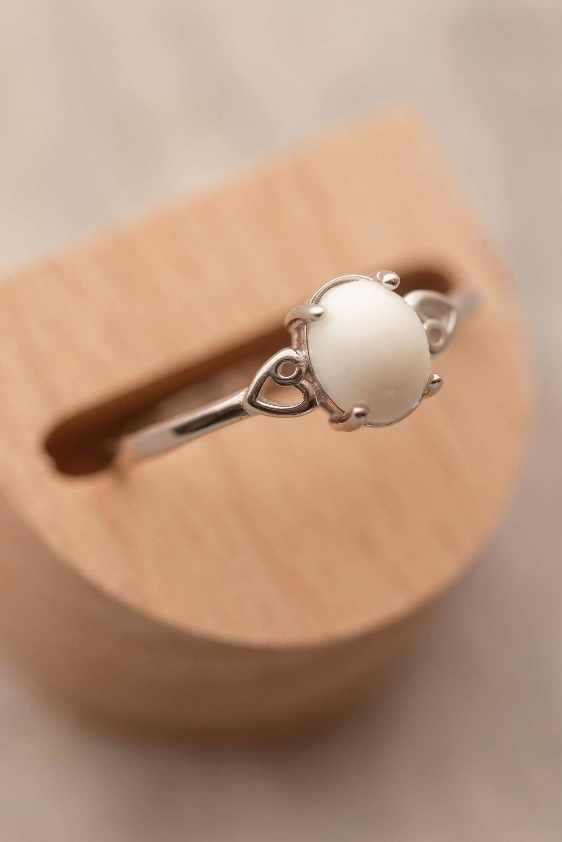 Bague en argent avec au centre un cabochon ovale de lait maternel entourée de 2 coeurs dans le corps de la bague