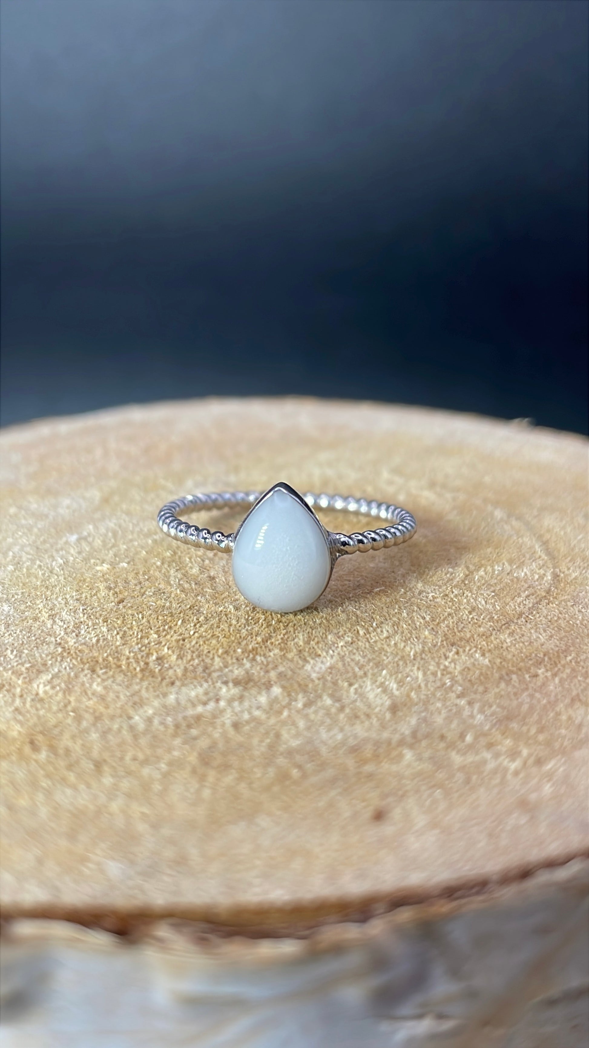 Bague représentant une goutte avec un corps de bague torsadé et délicat. Elle contient le souvenir de votre choix, comme ici du lait maternel. 