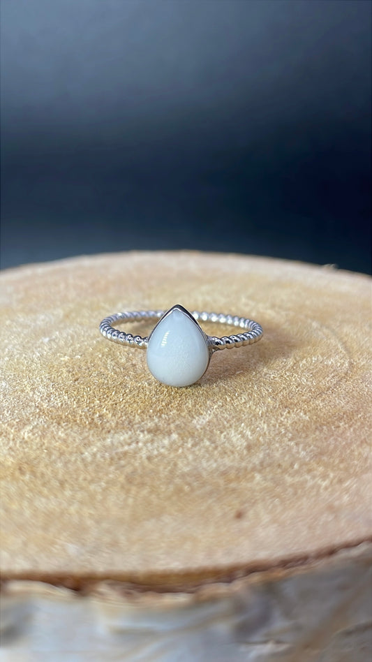 Bague représentant une goutte avec un corps de bague torsadé et délicat. Elle contient le souvenir de votre choix, comme ici du lait maternel. 
