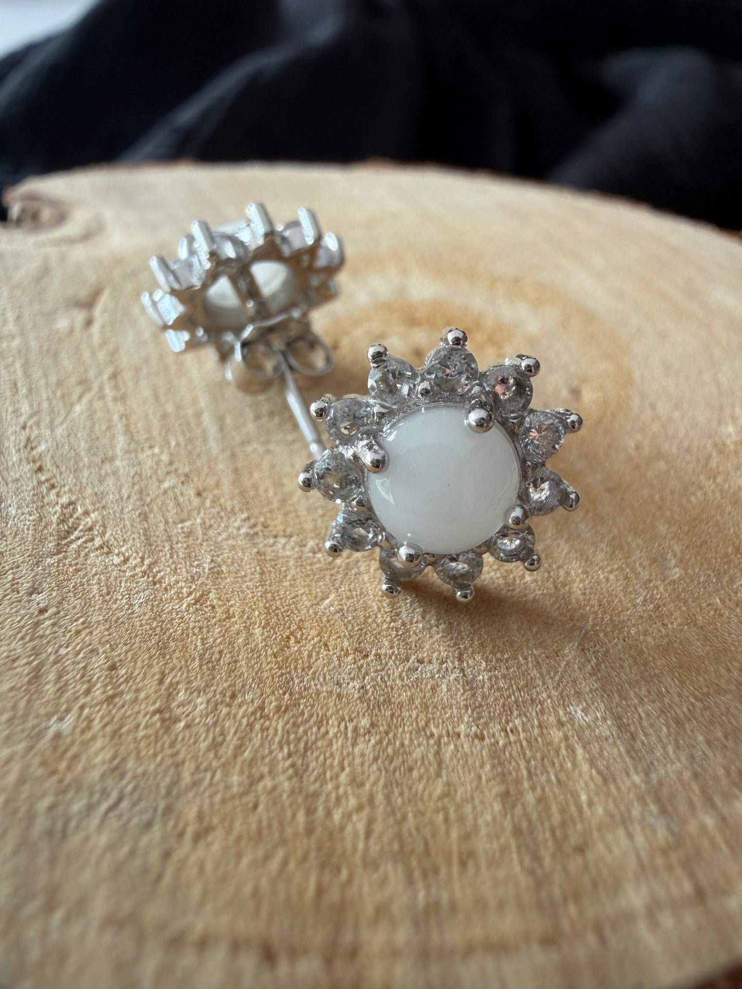 Boucle d'oreilles contenant au centre une pierre de lait maternel ornée de strass en forme de soleil 