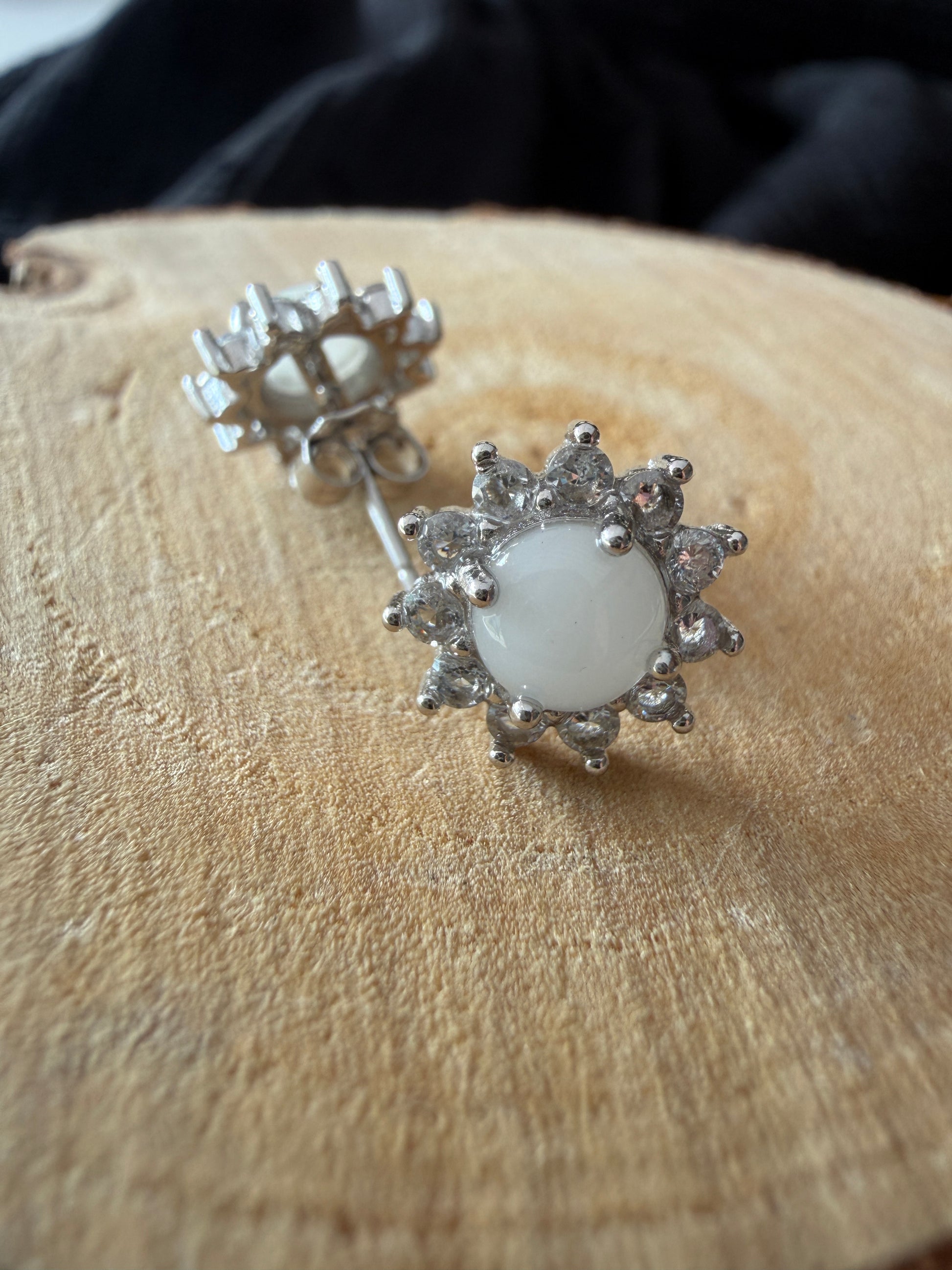 Boucle d'oreilles contenant au centre une pierre de lait maternel ornée de strass en forme de soleil 