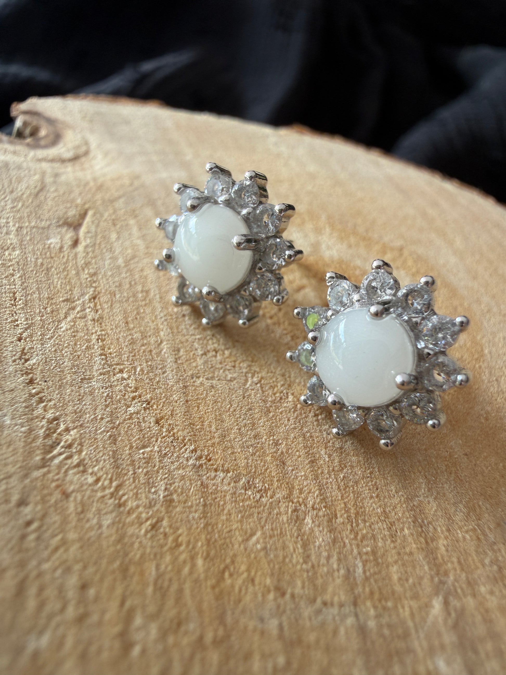 Boucle d'oreilles contenant au centre une pierre de lait maternel ornée de strass en forme de soleil 