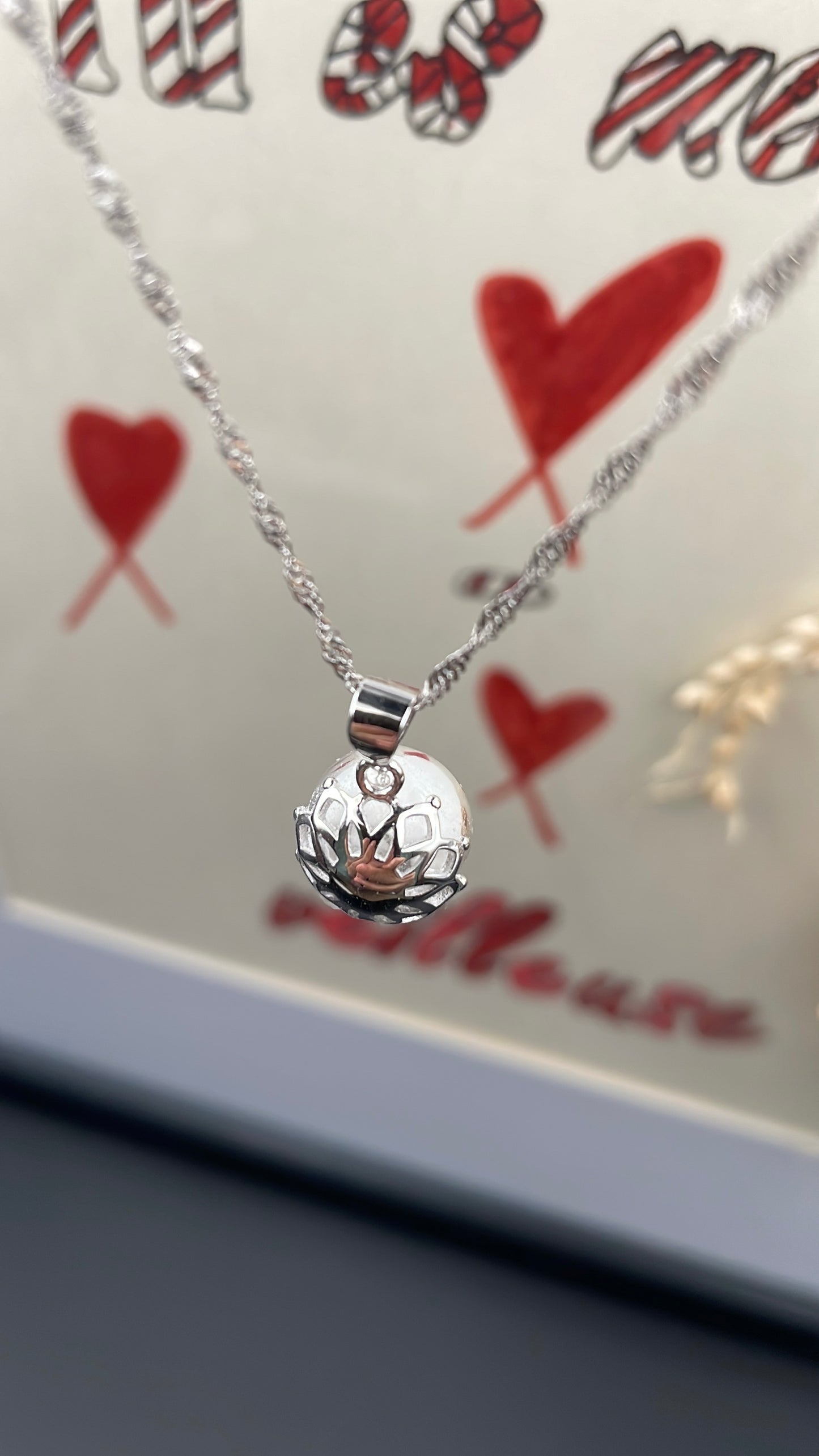 Pendentif orné d'une perle en verre contenant de la poule de lait maternel éternelle