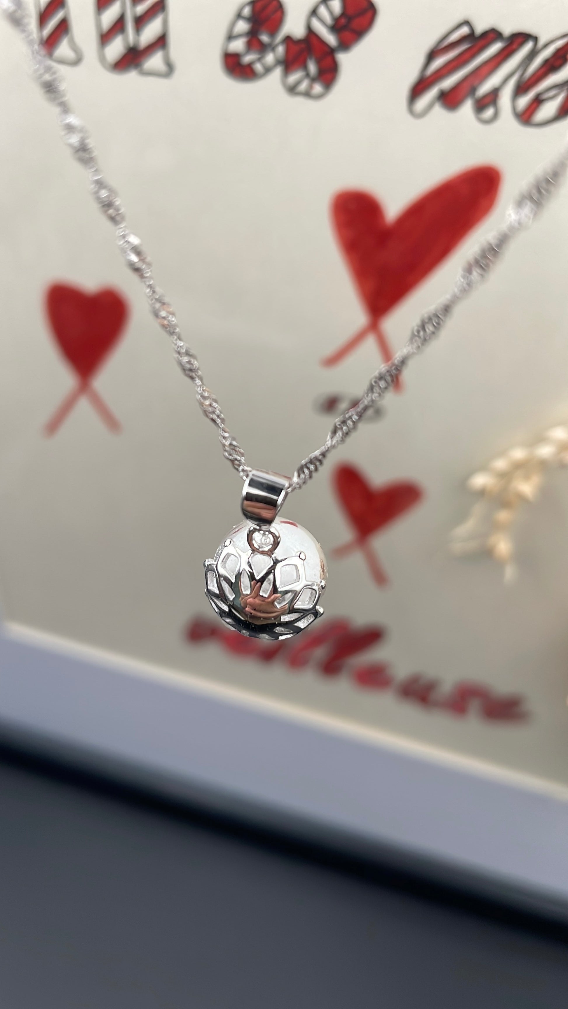 Pendentif orné d'une perle en verre contenant de la poule de lait maternel éternelle