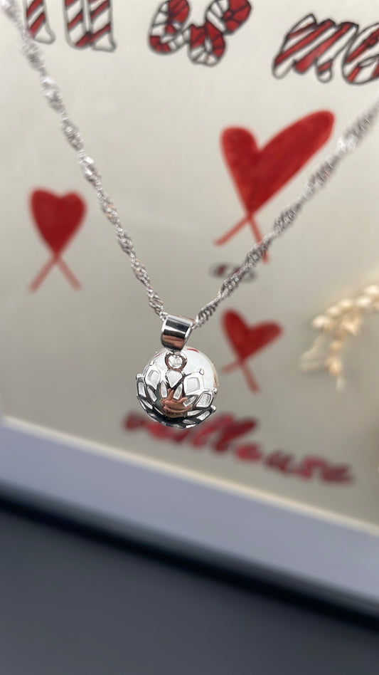 Pendentif orné d'une perle en verre contenant de la poule de lait maternel éternelle