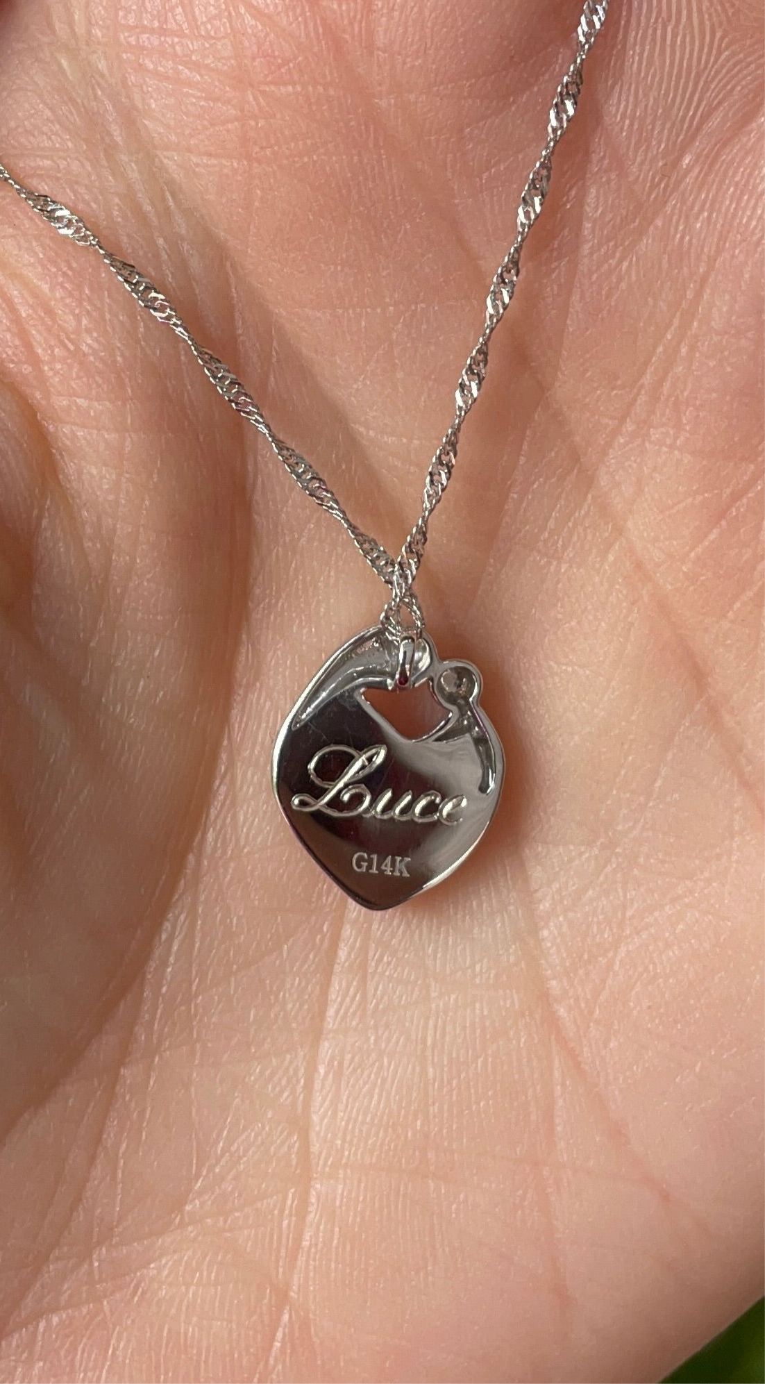 Pendentif en forme de coeur avec silhouette de maman et bébé contenant du lait maternel, cheveux de bébé ou fragment de cordon ombilical avec gravure personnalisée au dos. 