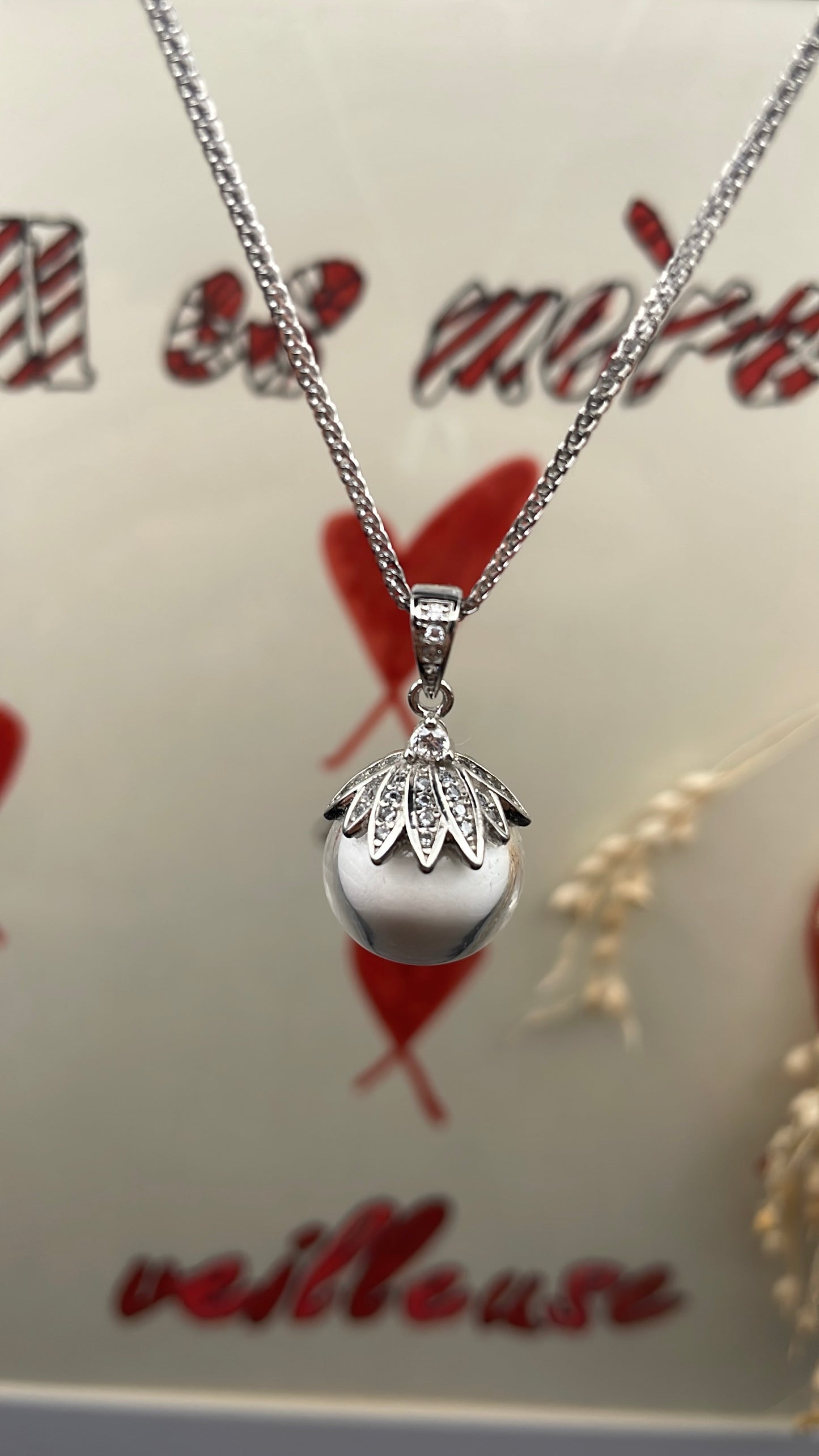 Pendentif orné d'une perle en verre contenant de la poule de lait maternel éternelle