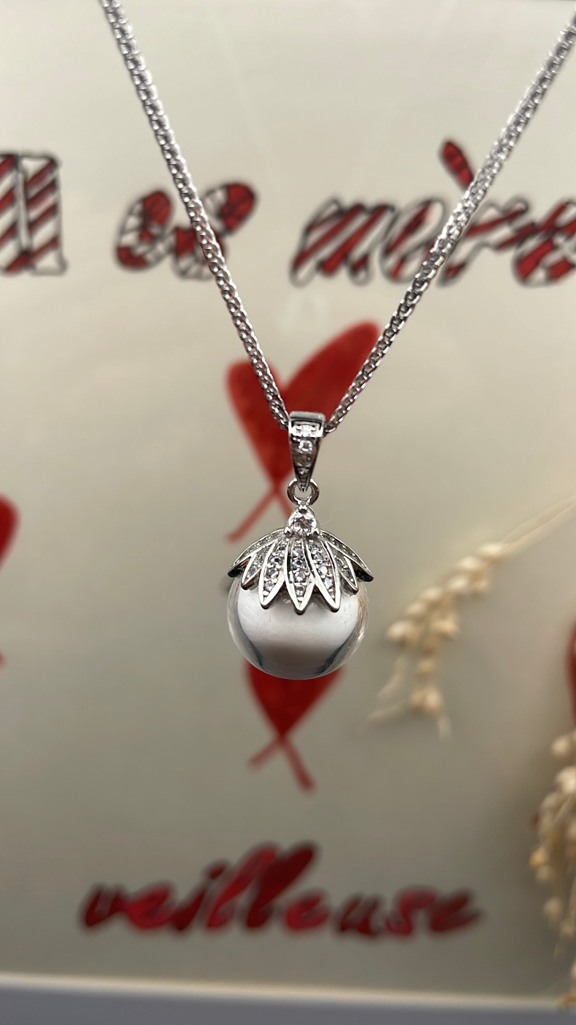 Pendentif orné d'une perle en verre contenant de la poule de lait maternel éternelle