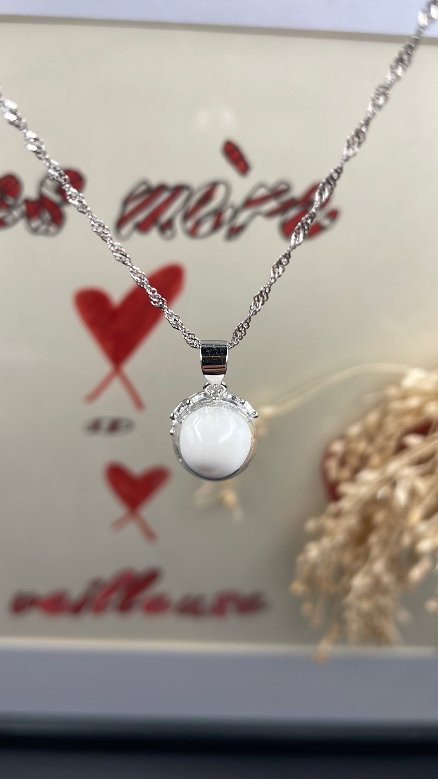 Pendentif orné d'une perle en verre contenant de la poule de lait maternel éternelle